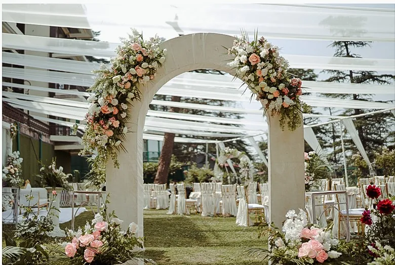 Floral archway at outdoor wedding ceremony in garden setting