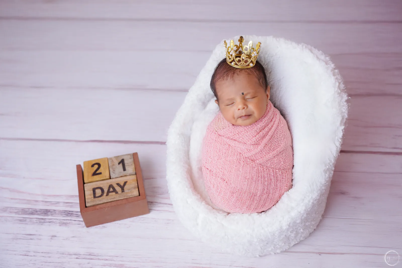 Newborn baby peacefully posed on a soft blanket during a photoshoot