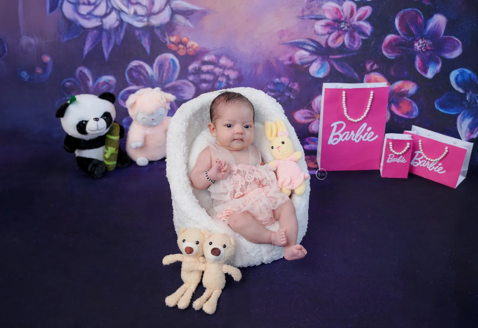 Newborn baby lying peacefully in a styled photoshoot arrangement